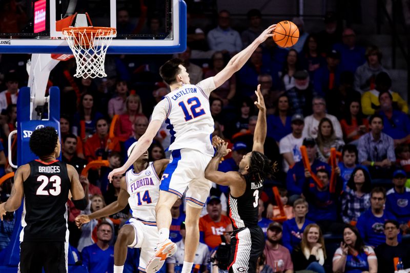 Jan 7, 2023; Gainesville, Florida, USA; Florida Gators forward Colin Castleton (12) blocks a shot from Georgia Bulldogs guard Kario Oquendo (3) during the second half at Exactech Arena at the Stephen C. O'Connell Center. Mandatory Credit: Matt Pendleton-USA TODAY Sports