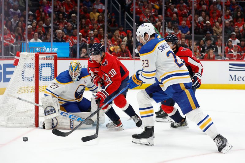 Nov 22, 2023; Washington, District of Columbia, USA; Washington Capitals defenseman Rasmus Sandin (38) and Buffalo Sabres defenseman Mattias Samuelsson (23) battle for the puck in front of Sabres goaltender Devon Levi (27) in the third period at Capital One Arena. Mandatory Credit: Geoff Burke-USA TODAY Sports