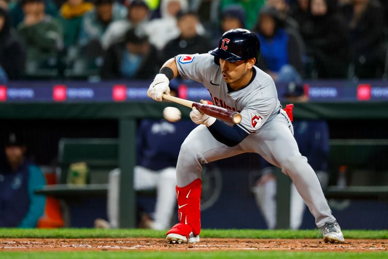 Apr 2, 2024; Seattle, Washington, USA; Cleveland Guardians left fielder Steven Kwan (38) bunts for a single against the Seattle Mariners during the fifth inning at T-Mobile Park. Mandatory Credit: Joe Nicholson-USA TODAY Sports