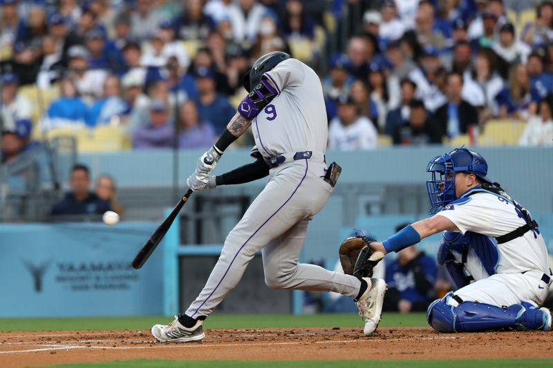 Jun 1, 2024; Los Angeles, California, USA;  Colorado Rockies center fielder Brenton Doyle (9) hits a sacrifice fly during the second inning against the Los Angeles Dodgers at Dodger Stadium. Mandatory Credit: Kiyoshi Mio-USA TODAY Sports