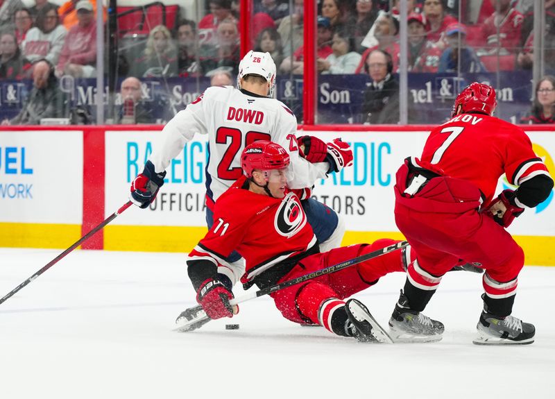 Apr 2, 2025; Raleigh, North Carolina, USA;  Carolina Hurricanes left wing Taylor Hall (71) holds Washington Capitals center Nic Dowd (26) during the second period at Lenovo Center. Mandatory Credit: James Guillory-Imagn Images