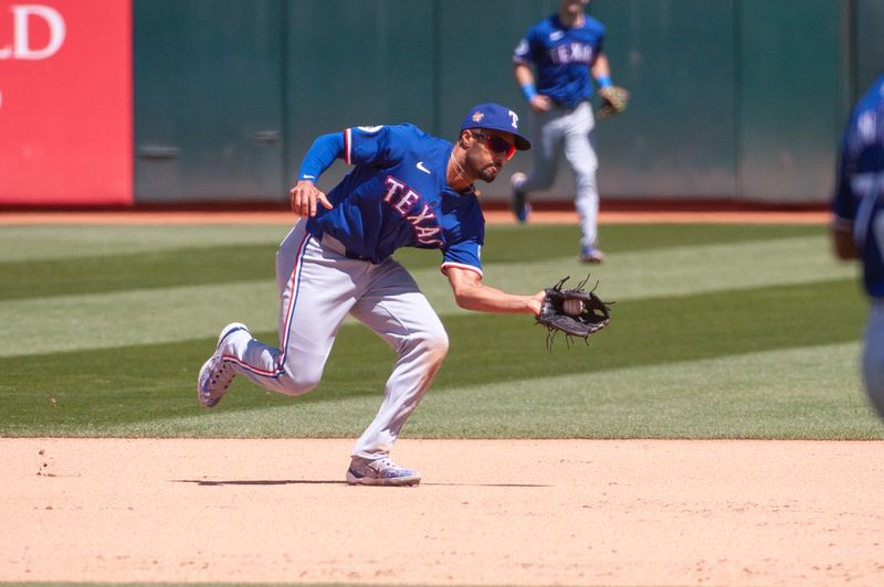 May 7, 2024; Oakland, California, USA; Texas Rangers second base Marcus Semien (2) fields the ball during the sixth inning of the game against the Oakland Athletics at Oakland-Alameda County Coliseum. Mandatory Credit: Ed Szczepanski-USA TODAY Sports