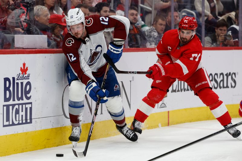 Feb 22, 2024; Detroit, Michigan, USA;  Colorado Avalanche center Ryan Johansen (12) skates with the puck while chased by Detroit Red Wings center Dylan Larkin (71) in the second period at Little Caesars Arena. Mandatory Credit: Rick Osentoski-USA TODAY Sports