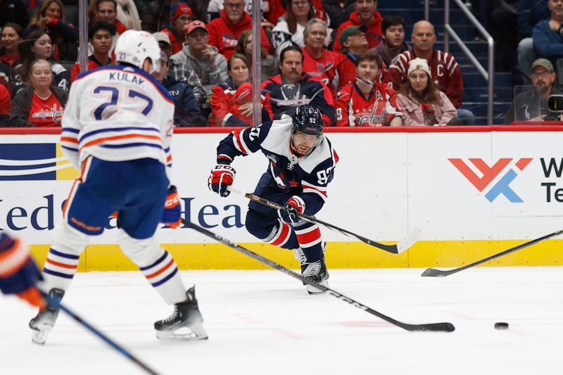 Nov 24, 2023; Washington, District of Columbia, USA; Washington Capitals center Evgeny Kuznetsov (92) passes the puck as Edmonton Oilers defenseman Brett Kulak (27) defends in the third period at Capital One Arena. Mandatory Credit: Geoff Burke-USA TODAY Sports