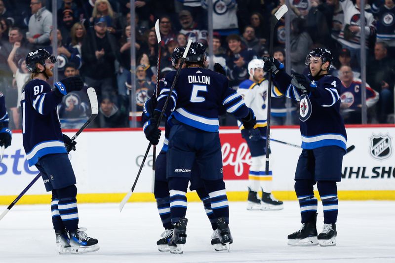 Feb 27, 2024; Winnipeg, Manitoba, CAN; Winnipeg Jets defenseman Brenden Dillon (5) is congratulated by his team mates on his goal against the St. Louis Blues during the first period at Canada Life Centre. Mandatory Credit: Terrence Lee-USA TODAY Sports