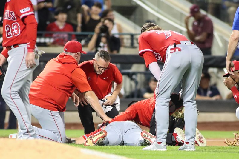 Aug 26, 2023; New York City, New York, USA;  Los Angeles Angels starting pitcher Chase Silseth (63) lays on the ground after getting hit in the head by a throw in the fourth inning against the New York Mets at Citi Field. Mandatory Credit: Wendell Cruz-USA TODAY Sports