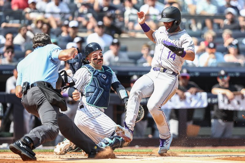 Aug 24, 2024; Bronx, New York, USA;  New York Yankees catcher Austin Wells (28) is unable to hold onto the ball allowing Colorado Rockies shortstop Ezequiel Tovar (14) to score in the first inning at Yankee Stadium. Mandatory Credit: Wendell Cruz-USA TODAY Sports