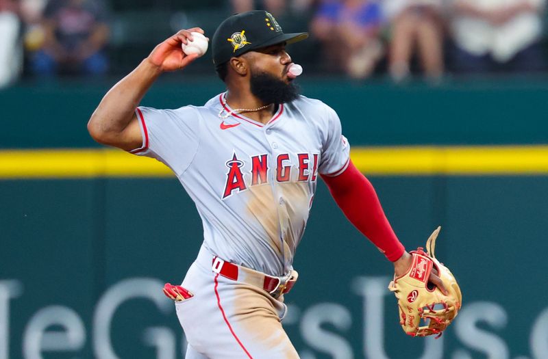 May 19, 2024; Arlington, Texas, USA; Los Angeles Angels third baseman Luis Rengifo (2) throws to first base while blowing a bubble during the seventh inning against the Texas Rangers at Globe Life Field. Mandatory Credit: Kevin Jairaj-USA TODAY Sports