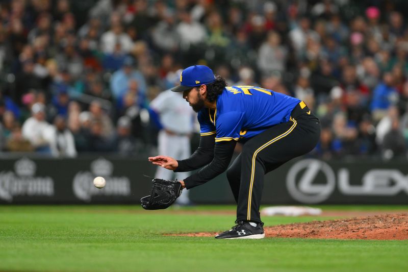 Sep 14, 2024; Seattle, Washington, USA; Seattle Mariners relief pitcher Andres Munoz (75) fields a ground ball against the Texas Rangers during the ninth inning at T-Mobile Park. Mandatory Credit: Steven Bisig-Imagn Images