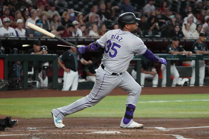 Aug 12, 2024; Phoenix, Arizona, USA; Colorado Rockies catcher Elias Díaz (35) hits an RBI single against the Arizona Diamondbacks in the third inning at Chase Field. Mandatory Credit: Rick Scuteri-USA TODAY Sports