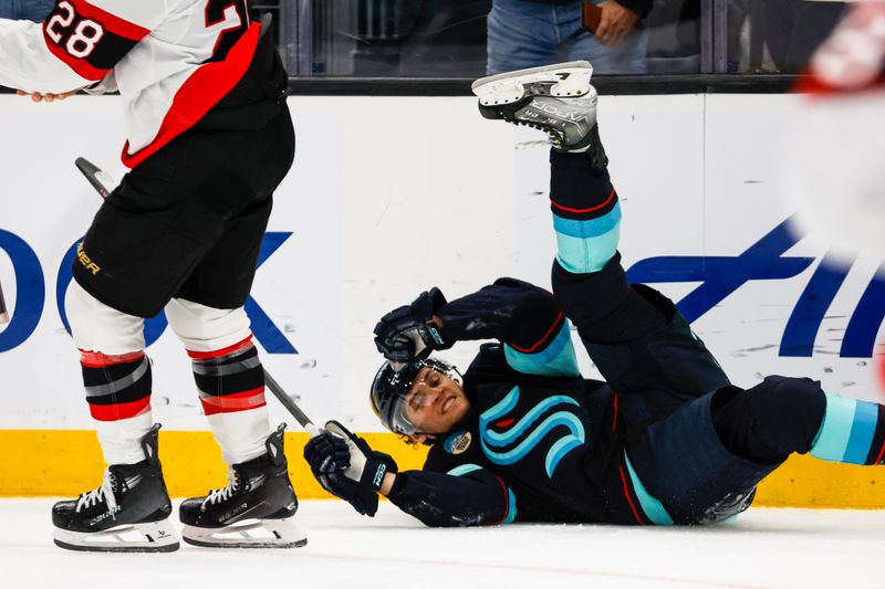 Jan 4, 2024; Seattle, Washington, USA; Seattle Kraken left wing Andre Burakovsky (95) celebrates while falling to the ice after scoring a goal against the Ottawa Senators during the second period at Climate Pledge Arena. Mandatory Credit: Joe Nicholson-USA TODAY Sports