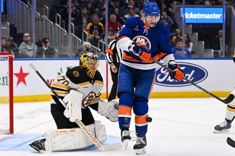 Nov 27, 2024; Elmont, New York, USA;  New York Islanders right wing Maxim Tsyplakov (7) attempts to screen Boston Bruins goaltender Joonas Korpisalo (70) during the second period at UBS Arena. Mandatory Credit: Dennis Schneidler-Imagn Images