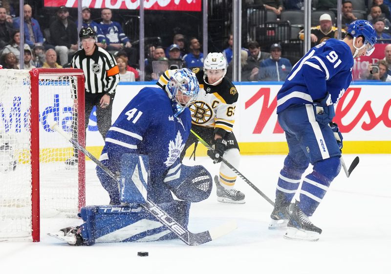 Nov 5, 2024; Toronto, Ontario, CAN; Toronto Maple Leafs goaltender Anthony Stolarz (41) handles the puck as Boston Bruins left wing Brad Marchand (63) looks for a rebound during the second period at Scotiabank Arena. Mandatory Credit: Nick Turchiaro-Imagn Imagess