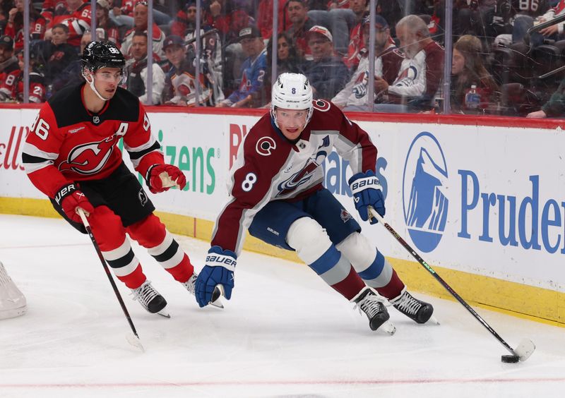 Oct 26, 2025; Newark, New Jersey, USA; Colorado Avalanche defenseman Cale Makar (8) skates with the puck as New Jersey Devils center Jack Hughes (86) defends during the first period at Prudential Center. Mandatory Credit: Ed Mulholland-Imagn Images