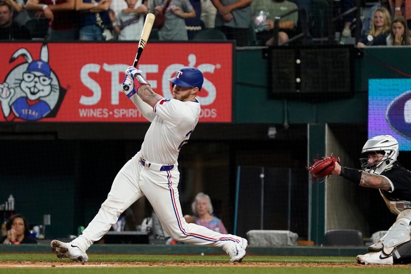 Jul 22, 2024; Arlington, Texas, USA; Texas Rangers catcher Jonah Heim (28) hits an RBI single during the ninth inning against the Chicago White Sox at Globe Life Field. Mandatory Credit: Raymond Carlin III-USA TODAY Sports