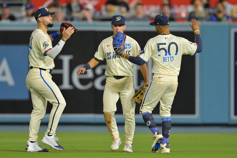 Sep 7, 2024; Los Angeles, California, USA; Los Angeles Dodgers left fielder Andy Pages (44), center fielder Tommy Edman (25) and right fielder Mookie Betts (50) celebrate after the final out the ninth inning defeating the Cleveland Guardians at Dodger Stadium. Mandatory Credit: Jayne Kamin-Oncea-Imagn Images