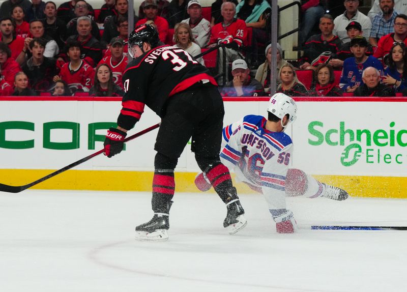 Mar 12, 2024; Raleigh, North Carolina, USA; New York Rangers defenseman Erik Gustafsson (56) checks Carolina Hurricanes right wing Andrei Svechnikov (37) during the first period at PNC Arena. Mandatory Credit: James Guillory-USA TODAY Sports