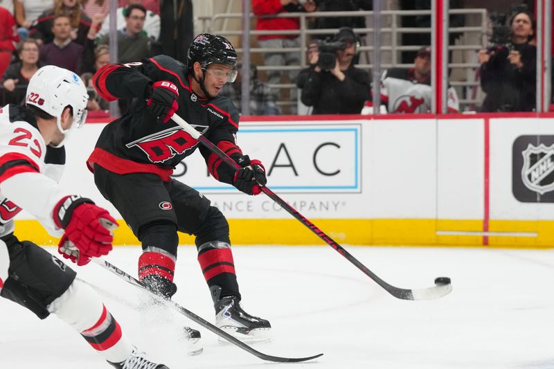 Oct 9, 2025; Raleigh, North Carolina, USA;  Carolina Hurricanes center Jesperi Kotkaniemi (82) takes a shot against the New Jersey Devils d1p at Lenovo Center. Mandatory Credit: James Guillory-Imagn Images
