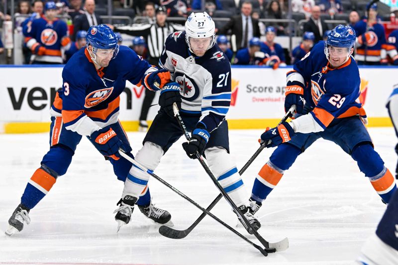 Mar 23, 2024; Elmont, New York, USA;  Winnipeg Jets left wing Nikolaj Ehlers (27) skates with the puck defended by New York Islanders defenseman Adam Pelech (3)  and New York Islanders center Brock Nelson (29) during the third period at UBS Arena. Mandatory Credit: Dennis Schneidler-USA TODAY Sports