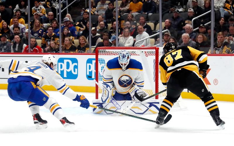 Oct 16, 2024; Pittsburgh, Pennsylvania, USA;  Buffalo Sabres goaltender Ukko-Pekka Luukkonen (1) makes a save against Pittsburgh Penguins center Sidney Crosby (87) as defenseman Bowen Byram (4) defends during the third period at PPG Paints Arena. Mandatory Credit: Charles LeClaire-Imagn Images