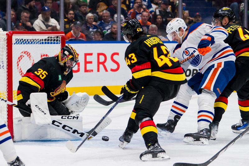 Nov 6, 2023; Vancouver, British Columbia, CAN; Vancouver Canucks defenseman Quinn Hughes (43) watches as goalie Thatcher Demko (35) makes a save on Edmonton Oilers forward Zach Hyman (18) in the second period at Rogers Arena. Mandatory Credit: Bob Frid-USA TODAY Sports