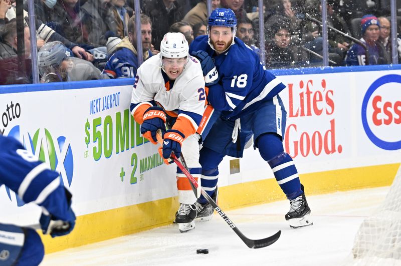 Feb 5, 2024; Toronto, Ontario, CAN;   New York Islanders defenseman Mike Reilly (2) moves the puck away from Toronto Maple Leafs forward Noah Gregor (18) in the second period at Scotiabank Arena. Mandatory Credit: Dan Hamilton-USA TODAY Sports