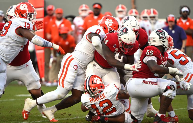 Oct 28, 2023; Raleigh, North Carolina, USA; North Carolina State Wolfpack running back Delbert Mimms III (34)  is tackled by Clemson Tigers linebacker Barrett Carter (0) during the second half at Carter-Finley Stadium. Mandatory Credit: Rob Kinnan-USA TODAY Sports