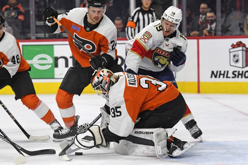 Dec 5, 2024; Philadelphia, Pennsylvania, USA; Philadelphia Flyers goaltender Aleksei Kolosov (35) covers the puck against Florida Panthers left wing Matthew Tkachuk (19) during the second period at Wells Fargo Center. Mandatory Credit: Eric Hartline-Imagn Images