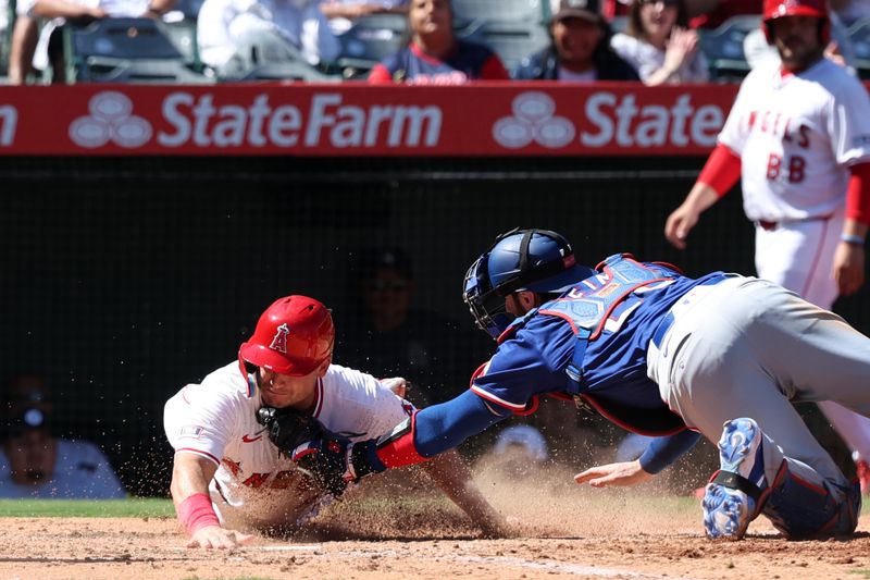 Sep 29, 2024; Anaheim, California, USA;  Texas Rangers catcher Jonah Heim (28) tags out Los Angeles Angels catcher Matt Thaiss (21) at home plate during the seventh inning at Angel Stadium. Mandatory Credit: Kiyoshi Mio-Imagn Images