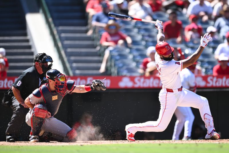 Aug 18, 2024; Anaheim, California, USA; Atlanta Braves catcher Sean Murphy (12) makes a catch against Los Angeles Angels outfielder Jo Adell (7) during the seventh inning at Angel Stadium. Mandatory Credit: Jonathan Hui-USA TODAY Sports