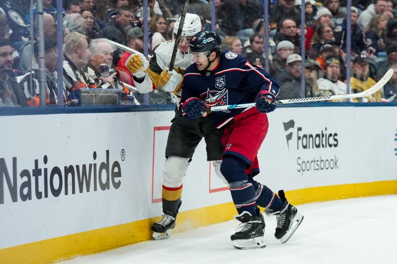 Dec 13, 2025; Columbus, Ohio, USA;  Columbus Blue Jackets left wing Miles Wood (11) checks Vegas Golden Knights defenseman Kaedan Korczak (6) in the second period at Nationwide Arena. Mandatory Credit: Aaron Doster-Imagn Images