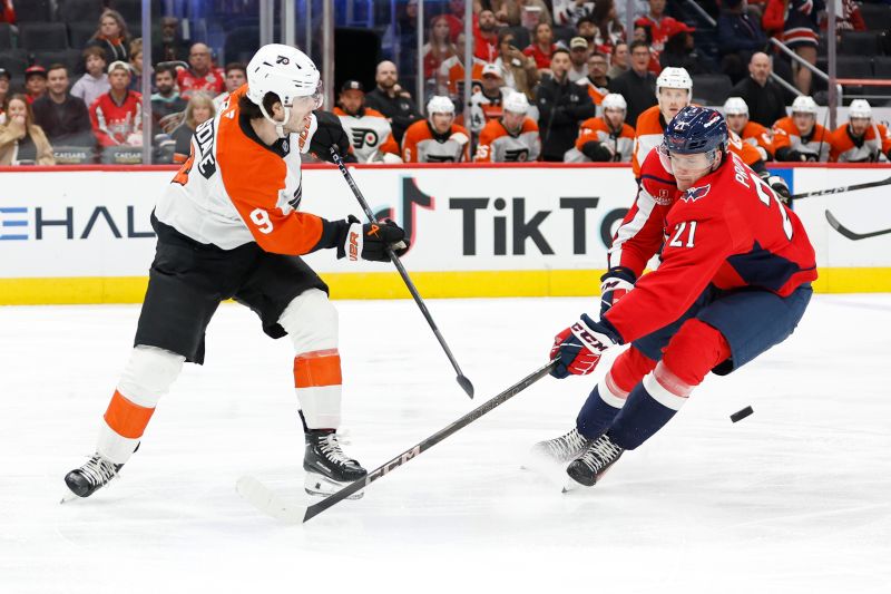 Oct 23, 2024; Washington, District of Columbia, USA; Philadelphia Flyers defenseman Jamie Drysdale (9) clears the puck from Washington Capitals center Aliaksei Protas (21) in the first period at Capital One Arena. Mandatory Credit: Geoff Burke-Imagn Images