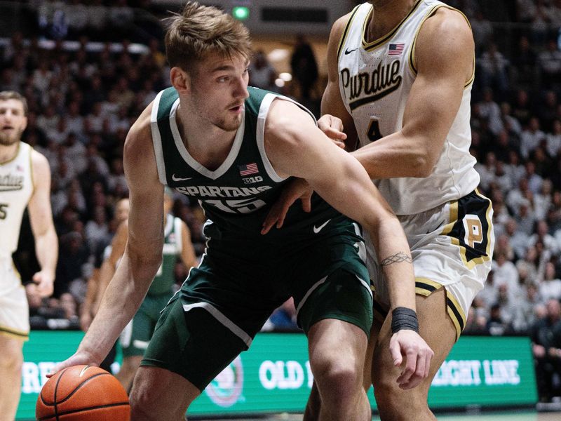 Feb 26, 2026; West Lafayette, Indiana, USA; Michigan State Spartans center Carson Cooper (15) dribbles around Purdue Boilermakers forward Trey Kaufman-Renn (4) during the first half at Mackey Arena. Mandatory Credit: Jacob Musselman-Imagn Images
