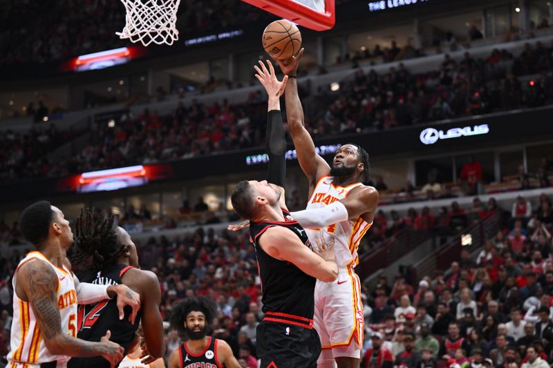 CHICAGO, ILLINOIS - APRIL 17:  Bruno Fernando #24 of the Atlanta Hawks shoots the ball against Nikola Vucevic #9 of the Chicago Bulls in the first half during the play-in tournament on April 17, 2024 at United Center in Chicago, Illinois. NOTE TO USER: User expressly acknowledges and agrees that, by downloading and or using this photograph, User is consenting to the terms and conditions of the Getty Images License Agreement.  (Photo by Jamie Sabau/Getty Images)