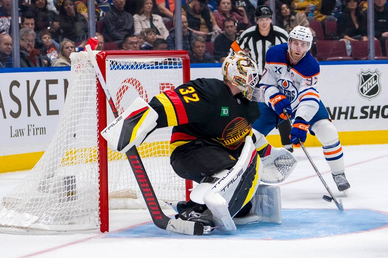 Nov 9, 2024; Vancouver, British Columbia, CAN; Vancouver Canucks goalie Kevin Lankinen (32) makes a save against Edmonton Oilers forward Connor McDavid (97) during the third period at Rogers Arena. Mandatory Credit: Bob Frid-Imagn Images