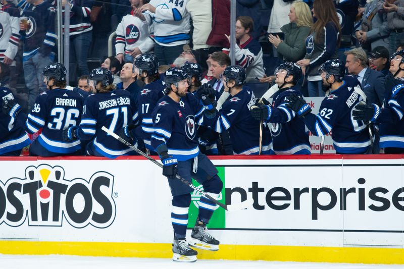 Jan 9, 2024; Winnipeg, Manitoba, CAN; Winnipeg Jets defenseman Brenden Dillon (5) is congratulated by his teammates on his goal against the Columbus Blue Jackets during the first period at Canada Life Centre. Mandatory Credit: Terrence Lee-USA TODAY Sports