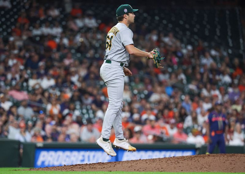 Sep 11, 2023; Houston, Texas, USA; Oakland Athletics relief pitcher Ken Waldichuk (64) leaps after a play during the seventh inning against the Houston Astros at Minute Maid Park. Mandatory Credit: Troy Taormina-USA TODAY Sports