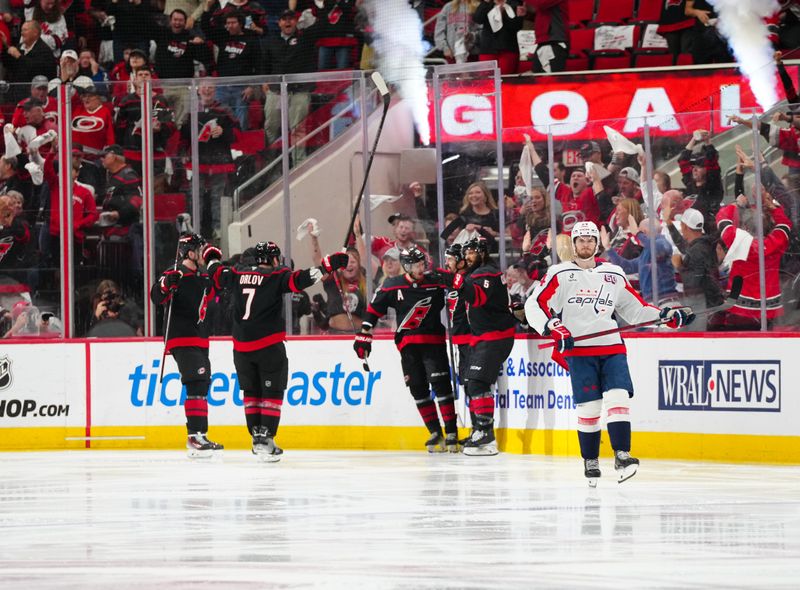 May 12, 2025; Raleigh, North Carolina, USA; Carolina Hurricanes center Seth Jarvis (24) celebrates his goal with  defenseman Jalen Chatfield (5) defenseman Dmitry Orlov (7) and right wing Andrei Svechnikov (37) against the Washington Capitals during the second period in game four of the second round of the 2025 Stanley Cup Playoffs at Lenovo Center. Mandatory Credit: James Guillory-Imagn Images