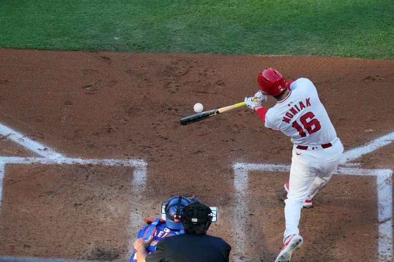 May 6, 2023; Anaheim, California, USA;  Los Angeles Angels center fielder Mickey Moniak (16) hits a two-run triple in the first inning as Texas Rangers catcher Jonah Heim (28) watches at Angel Stadium. Mandatory Credit: Kirby Lee-USA TODAY Sports