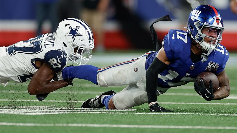 Dallas Cowboys cornerback Amani Oruwariye (27) pulls down New York Giants wide receiver Wan'Dale Robinson (17) during the fourth quarter of an NFL football game, Thursday, Sept. 26, 2024, in East Rutherford, N.J. (AP Photo/Adam Hunger)