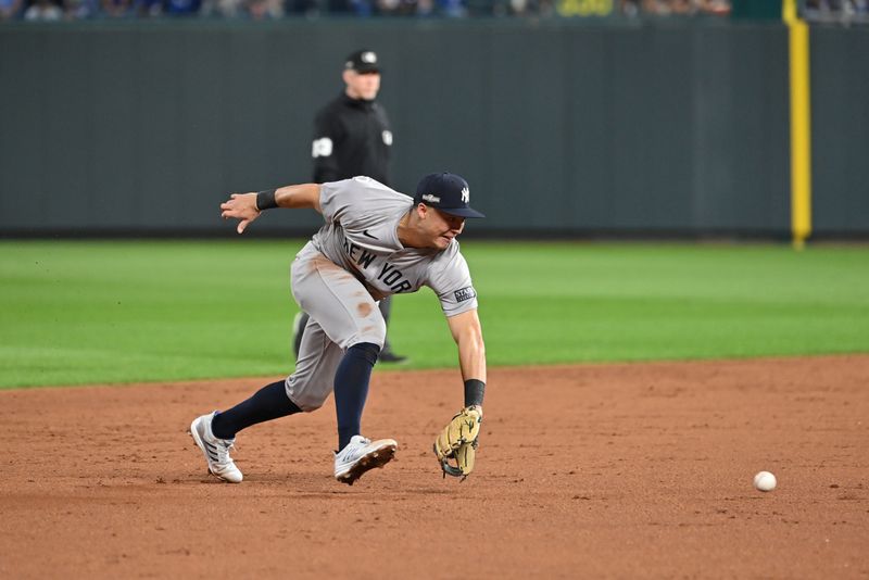 Oct 9, 2024; Kansas City, Missouri, USA; New York Yankees shortstop Anthony Volpe (11) fields the ball in the fifth inning against the Kansas City Royals during game three of the NLDS for the 2024 MLB Playoffs at Kauffman Stadium. Mandatory Credit: Peter Aiken-Imagn Images