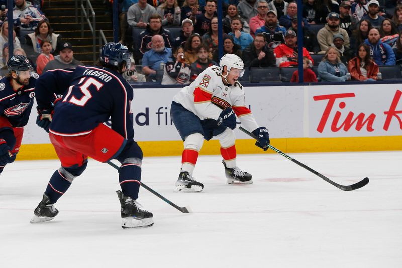 Mar 20, 2025; Columbus, Ohio, USA; Florida Panthers center Carter Verhaeghe (23) passes the puck as Columbus Blue Jackets defenseman Dante Fabbro (15) defends during the third period at Nationwide Arena. Mandatory Credit: Russell LaBounty-Imagn Images
