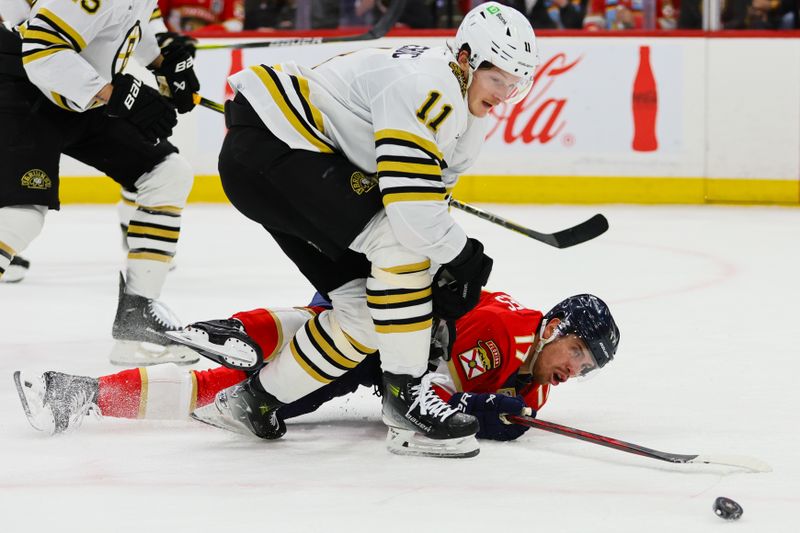 May 8, 2024; Sunrise, Florida, USA; Florida Panthers center Evan Rodrigues (17) dives for the puck against Boston Bruins center Trent Frederic (11) during the first period in game two of the second round of the 2024 Stanley Cup Playoffs at Amerant Bank Arena. Mandatory Credit: Sam Navarro-USA TODAY Sports