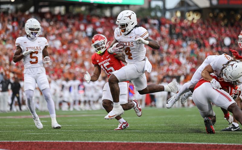 Oct 21, 2023; Houston, Texas, USA;  Texas Longhorns running back CJ Baxter (4) leaps with the ball and scores a touchdown during the fourth quarter against the Houston Cougars at TDECU Stadium. Mandatory Credit: Troy Taormina-USA TODAY Sports