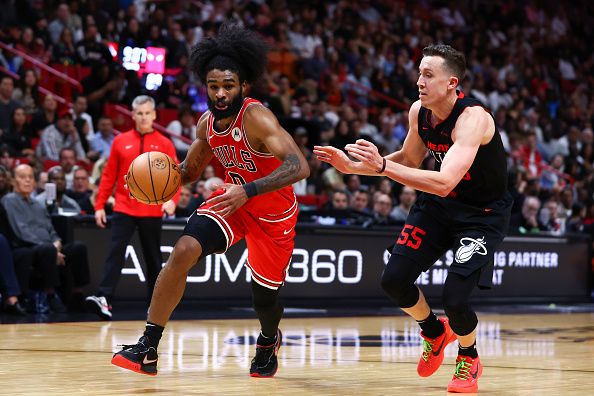 MIAMI, FLORIDA - DECEMBER 16: Coby White #0 of the Chicago Bulls drives against Duncan Robinson #55 of the Miami Heat during the fourth quarter of the game at Kaseya Center on December 16, 2023 in Miami, Florida. NOTE TO USER: User expressly acknowledges and agrees that, by downloading and or using this photograph, User is consenting to the terms and conditions of the Getty Images License Agreement. (Photo by Megan Briggs/Getty Images)