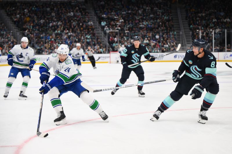 Feb 22, 2024; Seattle, Washington, USA; Vancouver Canucks center Pius Suter (24) advances the puck while defended by Seattle Kraken defenseman Brian Dumoulin (8) during the third period at Climate Pledge Arena. Mandatory Credit: Steven Bisig-USA TODAY Sports