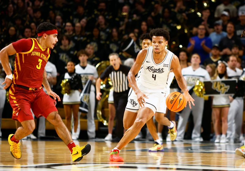 Feb 11, 2025; Orlando, Florida, USA;  Central Florida Knights center Keyshawn Hall (4) dribbles the ball up the court while Iowa State Cyclones guard Tamin Lipsey (3) attempts to defend at Addition Financial Arena. Mandatory Credit: Russell Lansford-Imagn Images