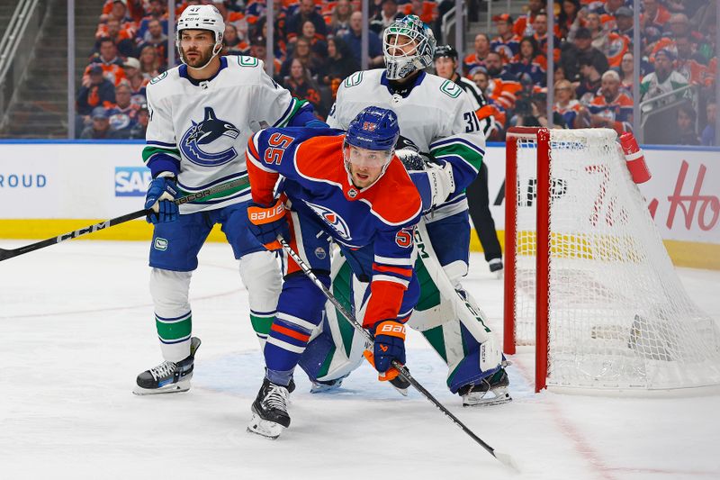 May 14, 2024; Edmonton, Alberta, CAN; Edmonton Oilers forward Dylan Holloway (55) battle for position against Vancouver Canucks defensemen Noah Juulsen (47) in front of goaltender Arturs Silovs (31)during the first period in game four of the second round of the 2024 Stanley Cup Playoffs at Rogers Place. Mandatory Credit: Perry Nelson-USA TODAY Sports