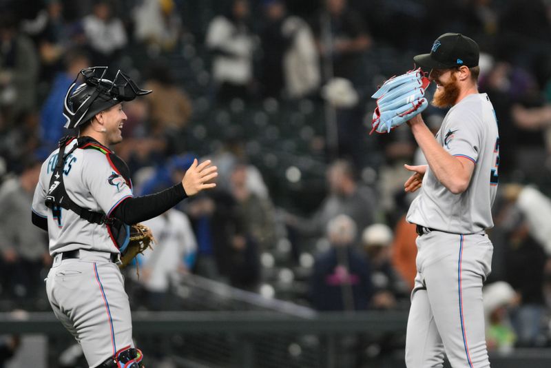 Jun 14, 2023; Seattle, Washington, USA; Miami Marlins catcher Nick Fortes (4) and relief pitcher A.J. Puk (35) celebrate defeating the Seattle Mariners at T-Mobile Park. Mandatory Credit: Steven Bisig-USA TODAY Sports