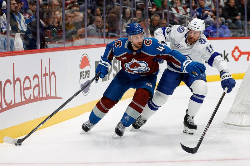 Oct 30, 2024; Denver, Colorado, USA; Colorado Avalanche defenseman Calvin de Haan (44) and Tampa Bay Lightning center Luke Glendening (11) battle for the puck in the first period at Ball Arena. Mandatory Credit: Isaiah J. Downing-Imagn Images